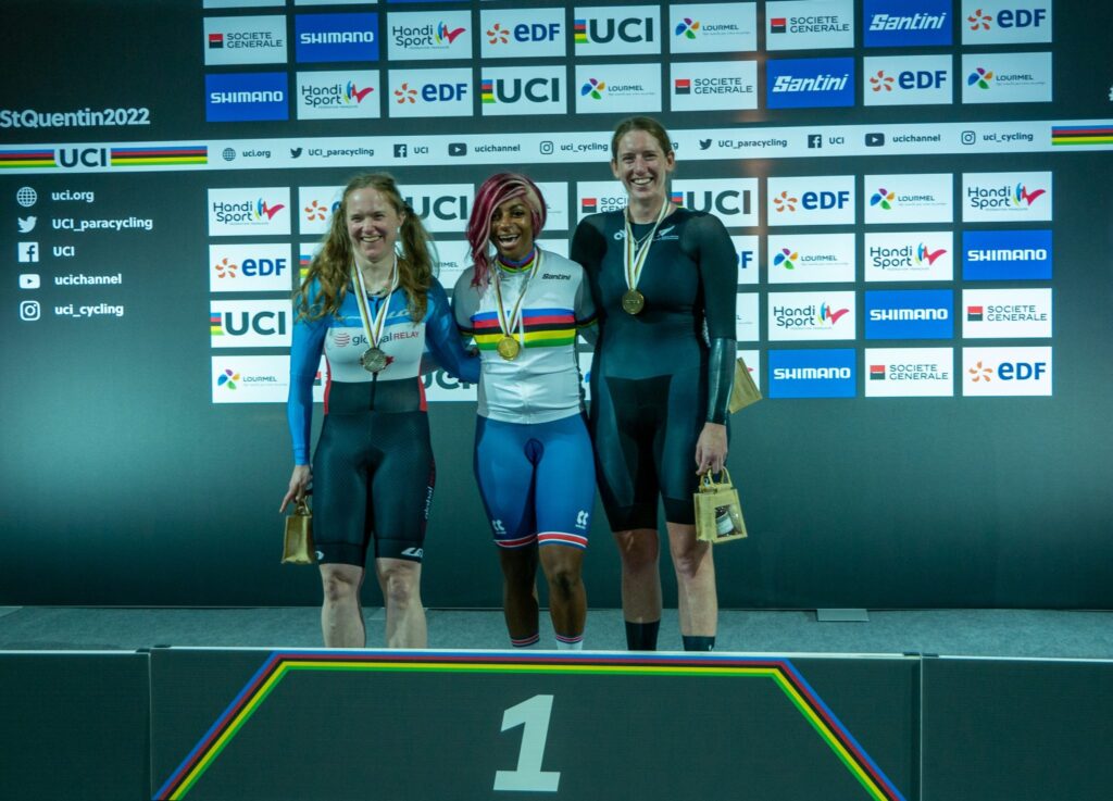 Anna Taylor on podium with bronze medal, standing next to two other medal winners