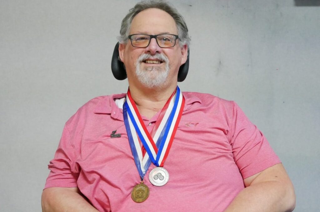 Paralympian Greg Cochrane with his 2 Paralympic medals and Paralympic pin