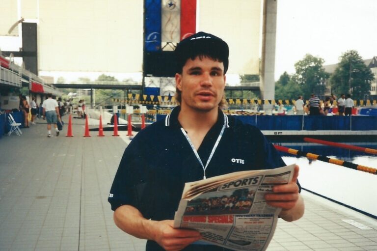 Paralympian Jason Griffiths with a newspaper in front of the Atlanta swimming pool