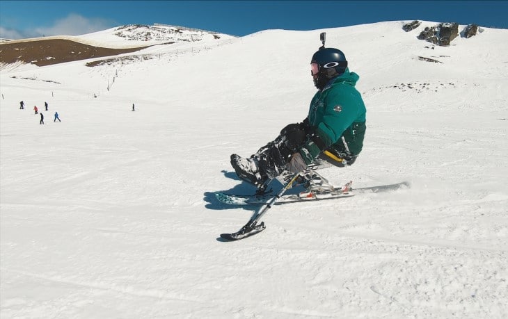 Bailley Unahi on her sit ski going down the snow slopes