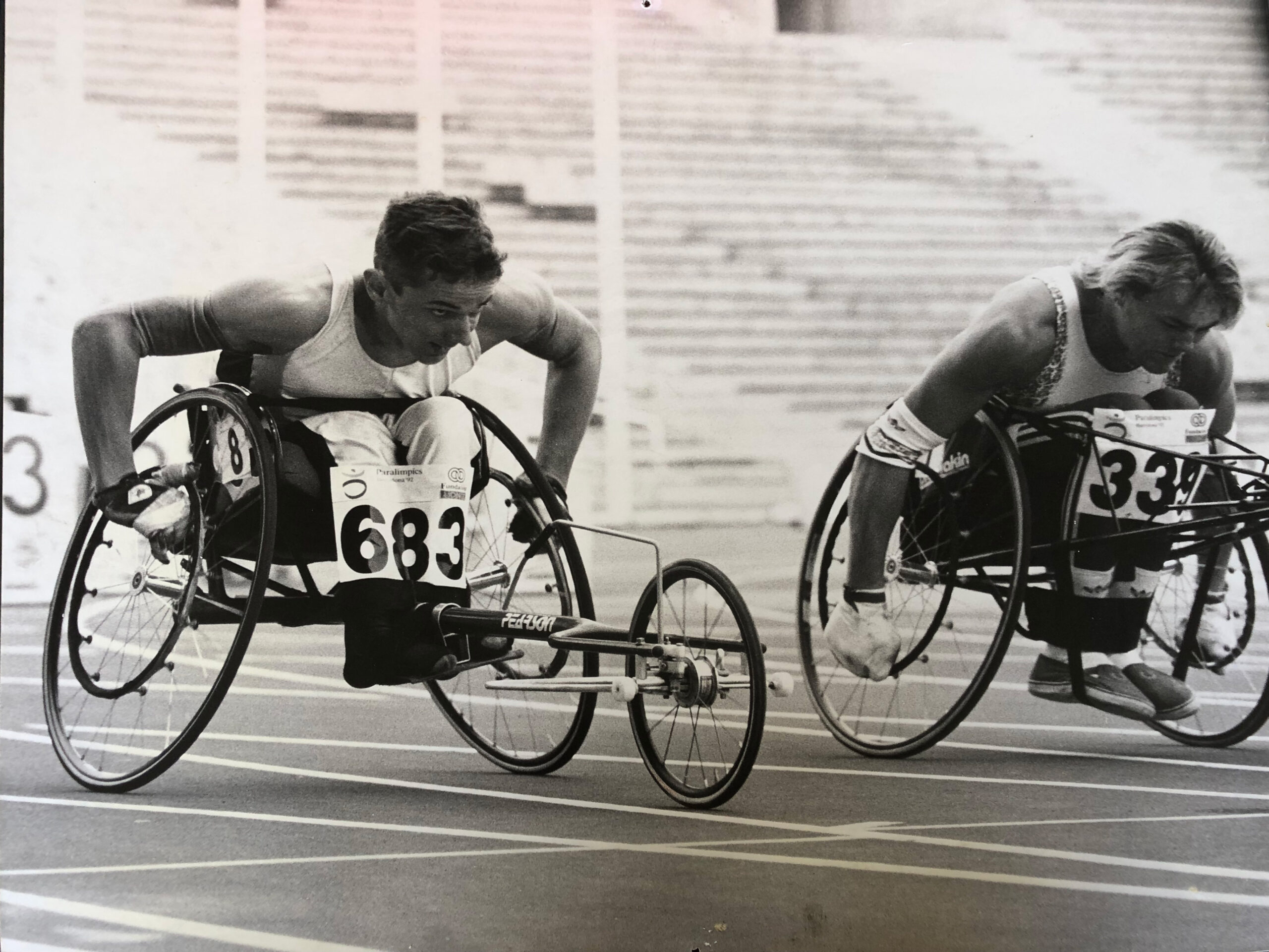 Evan Clulee in racing wheelchair alongside competitor