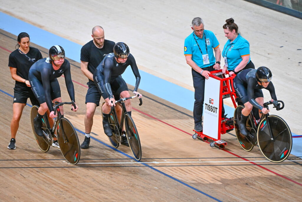 Devon, Nick and Nicole line up on the start line of the mixed sprint, supported by staff.