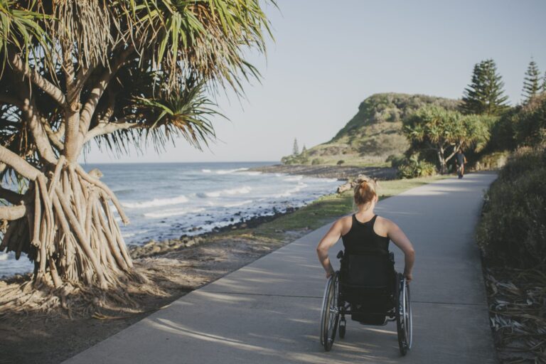 Paraplegic woman travelling in her wheelchair beside the ocean