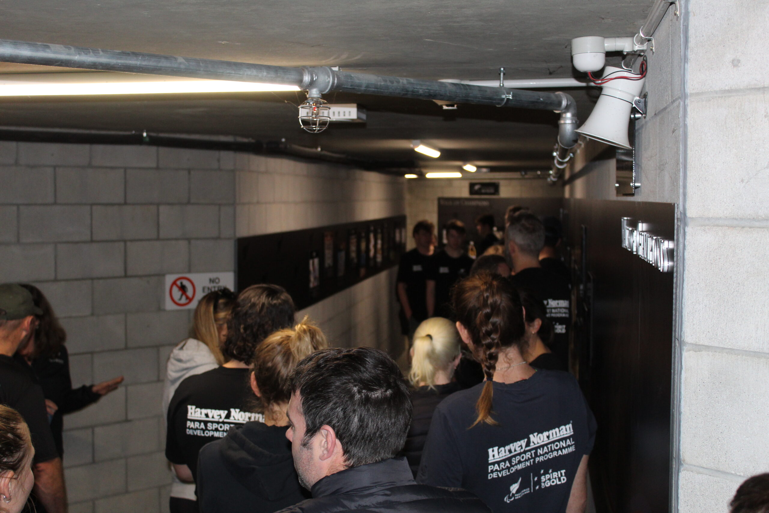 Group of people walking in the tunnel looking at plaques on the walls