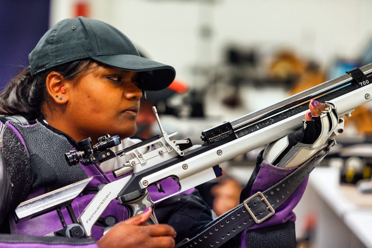 Close up on Neelam holding tight her riffle at the range with very focused expression