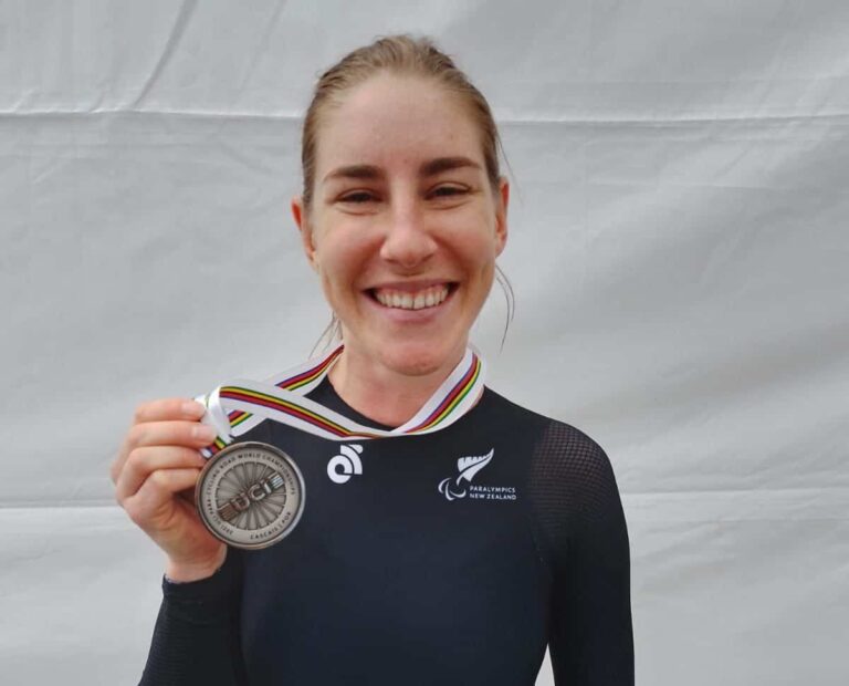 Nicole holds up silver medal with huge smile