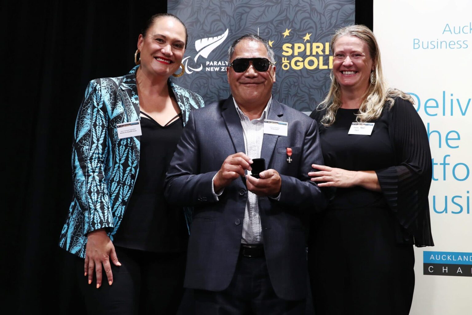 Paralympian Latoa Halatau receives his numbered paralympic pin by Fiona Allan and Minister for Disability Issues, Hon Carmel Sepuloni