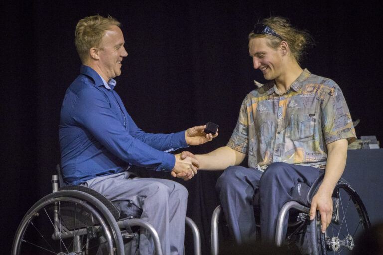 Corey Peters presents Aaron Ewen with Paralympic pin