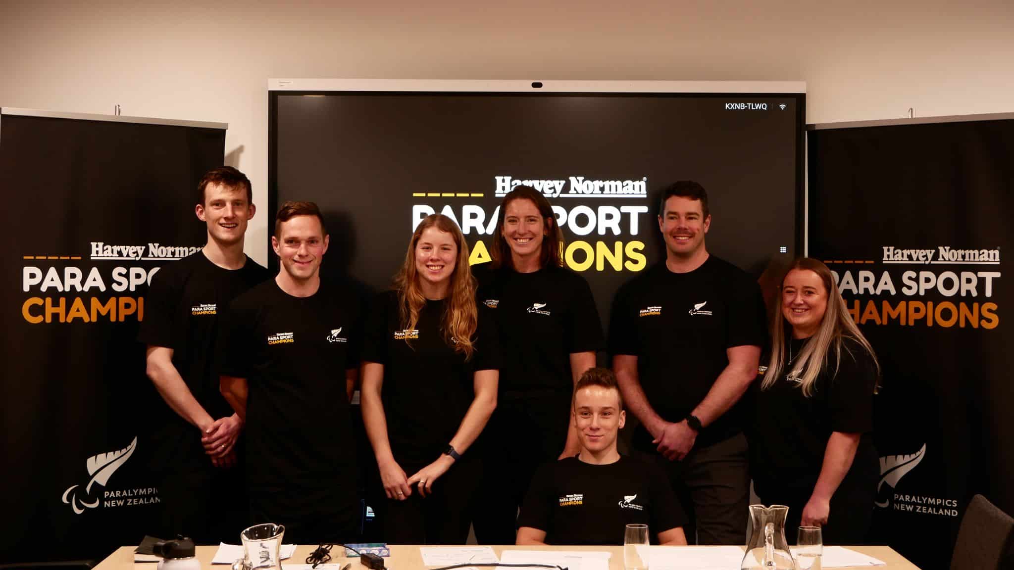 William Stedman, Mitch Joynt, Danielle Aitchison, Anna Taylor, Jaden Movold, Rory McSweeney, Caitlin Dore smiling in front of a banner saying Harvey Norman Para Sport Champions