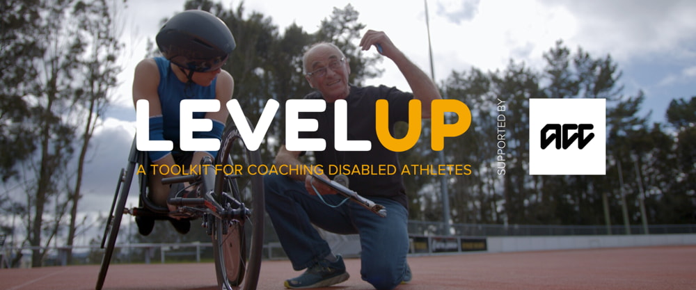An athletics coach explains something to an athlete in a racing wheelchair
