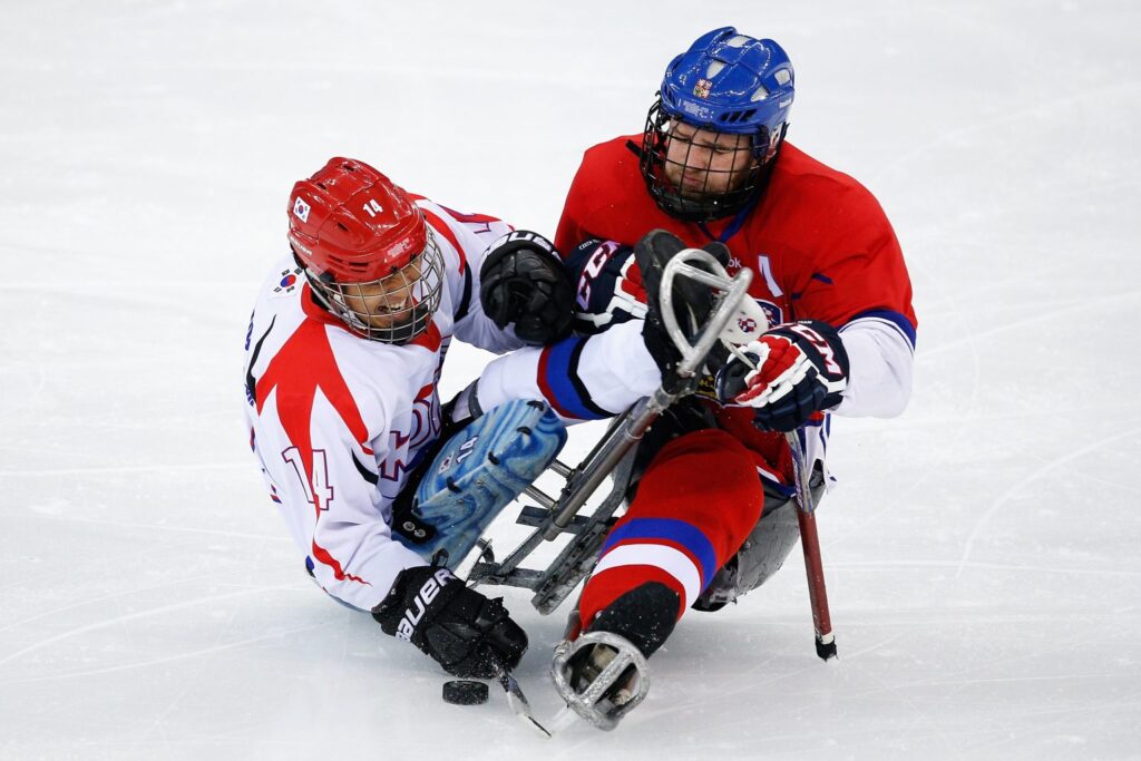 Two players tackling during a game of Para ice hockey