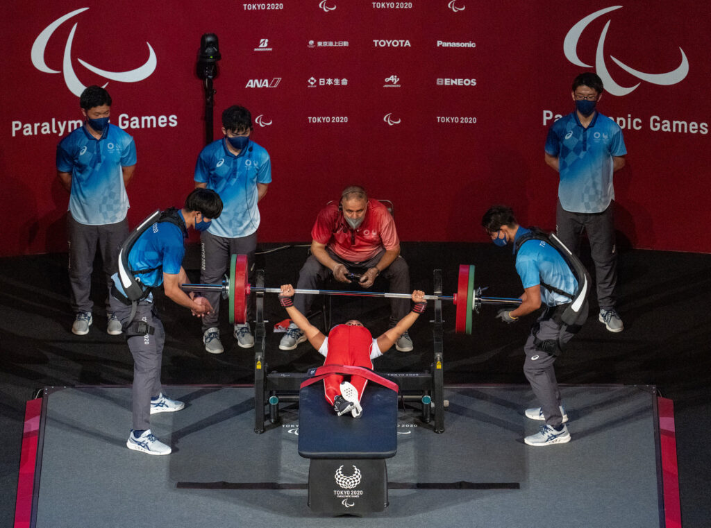 Female Para athlete strapped to bench at hips as she competes in Para powerlifting