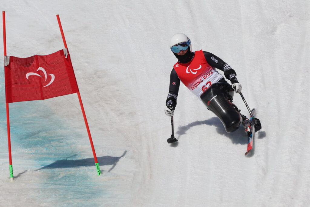 Corey Peters rounds a flag on his sit-ski, on what looks like a near vertical slope