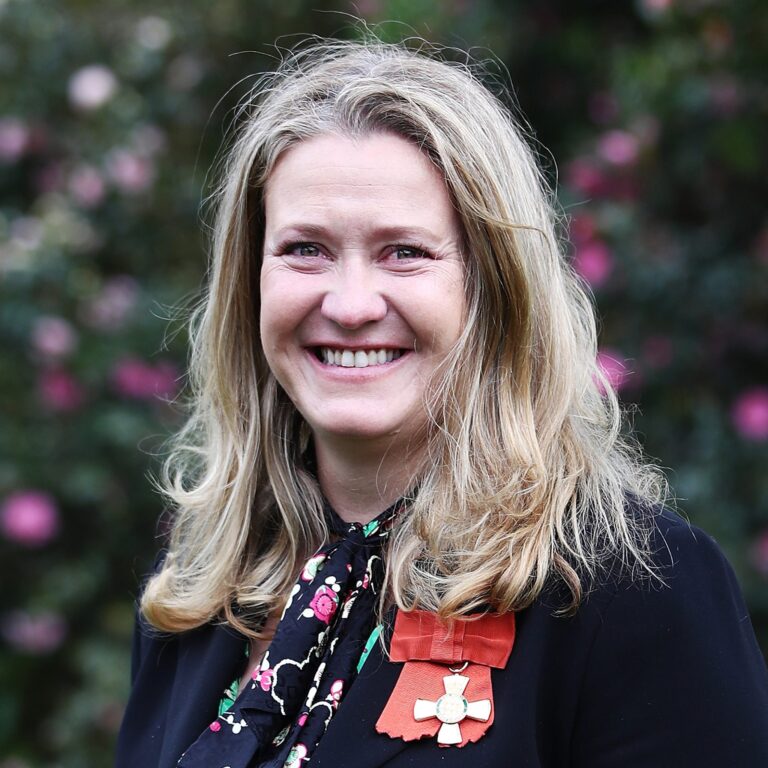Fiona Allan smiling, wearing the medal of her Order of Merit at her investiture