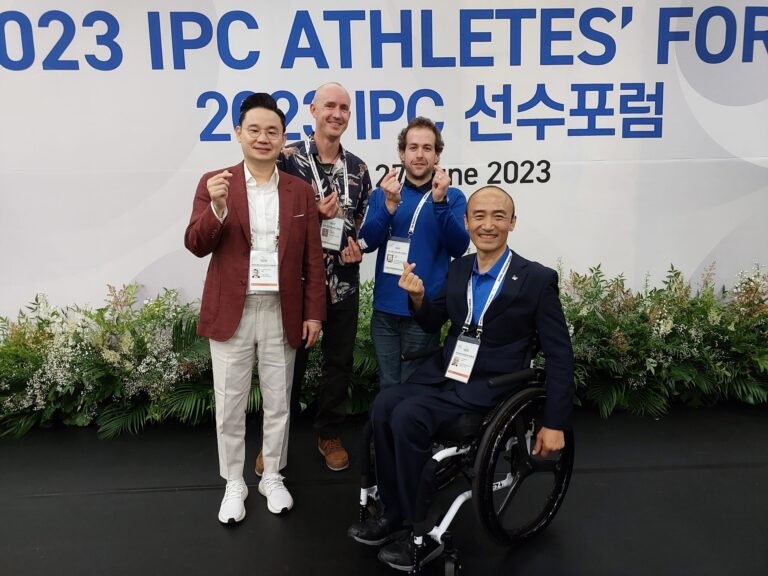 Adam Hall with Carl Murphy, Hosts Bae Dong-hyeon, chairman of the BDH Foundation and event sponsor and Jeong Jin-wan, president of the Korea Paralympic Committee pose for camera doing the finger heart sign in front of a sign for the forum