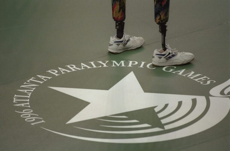 Logo and emblem of the Atlanta 1996 Paralympic Games engraved on the floor with person wearing two prosthetic legs in the corner