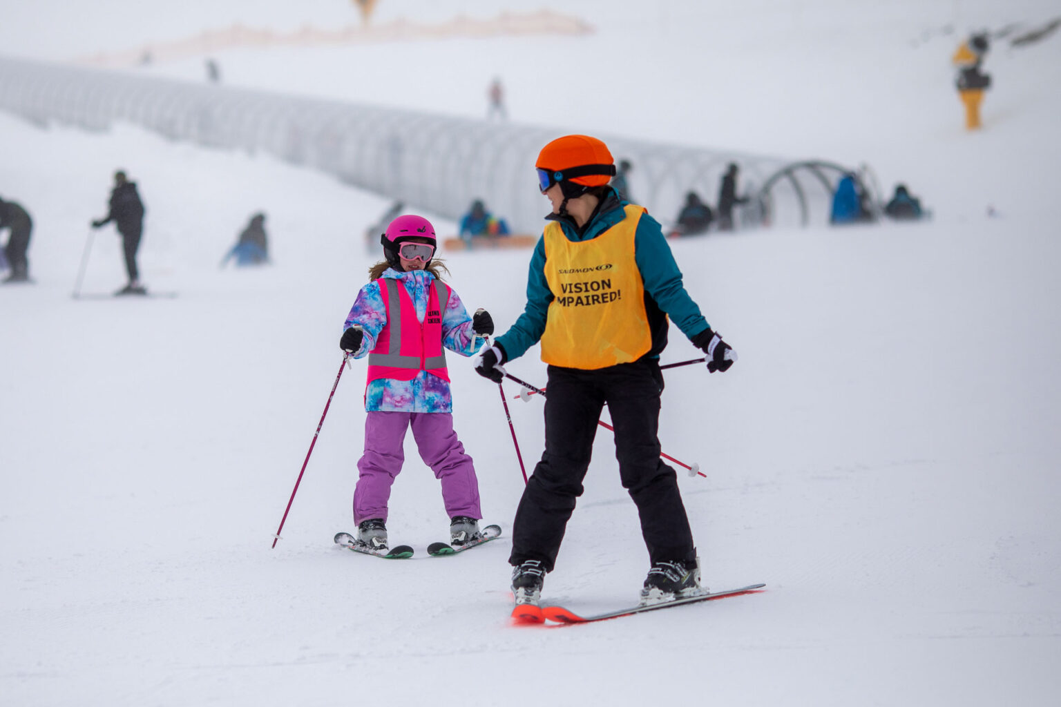 young visually impaired skier with guide