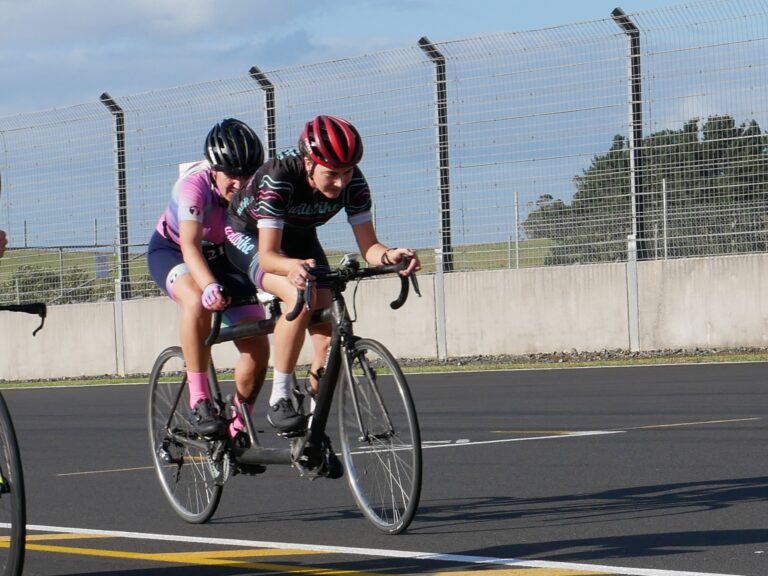 Tandem bike on fenced road with Hannah Pascoe behind and Sophie Williamson in front