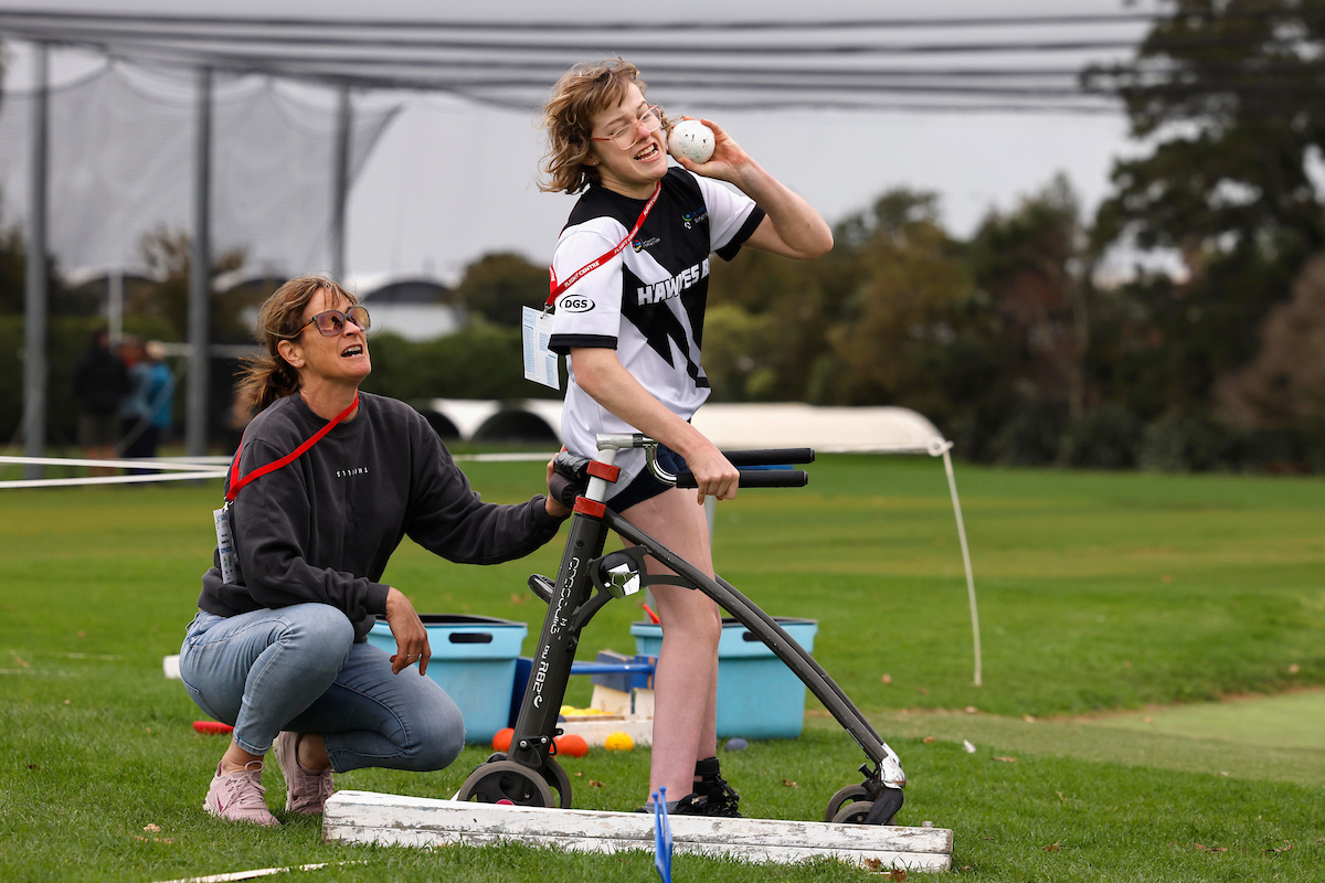 disabled shot putter in action with support staff member