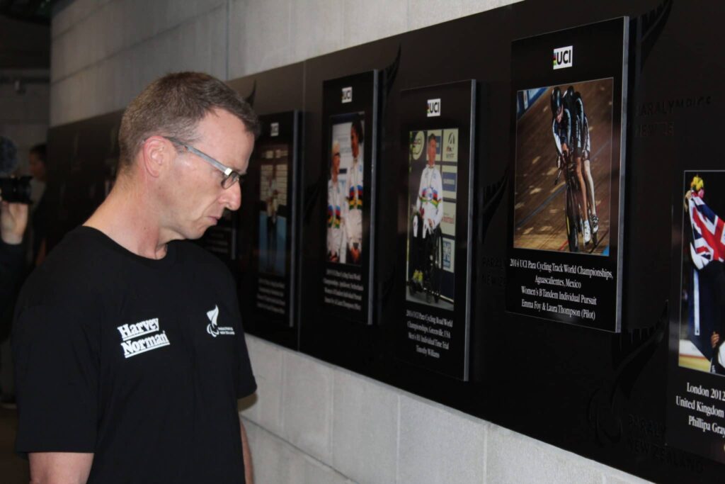 Para cyclist looking at plaques on a wall