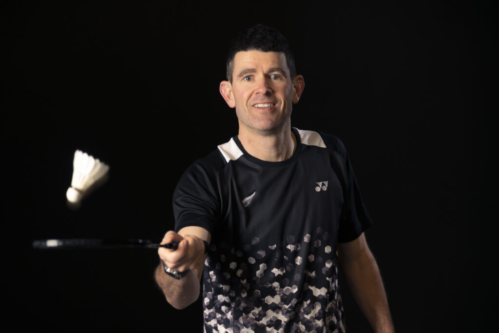 Thomas Slade tossing a shuttlecock with his badminton racquet in posed photograph