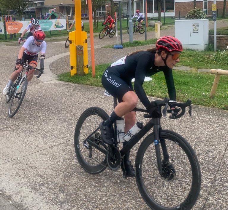Nicole Murray rounds corner in Road Race with another cyclist behind