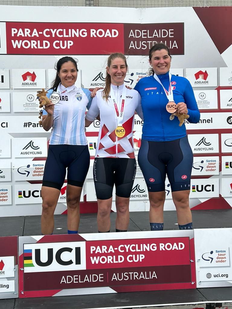 Nicole wears gold medal and smiles as she stands with other winners on podium