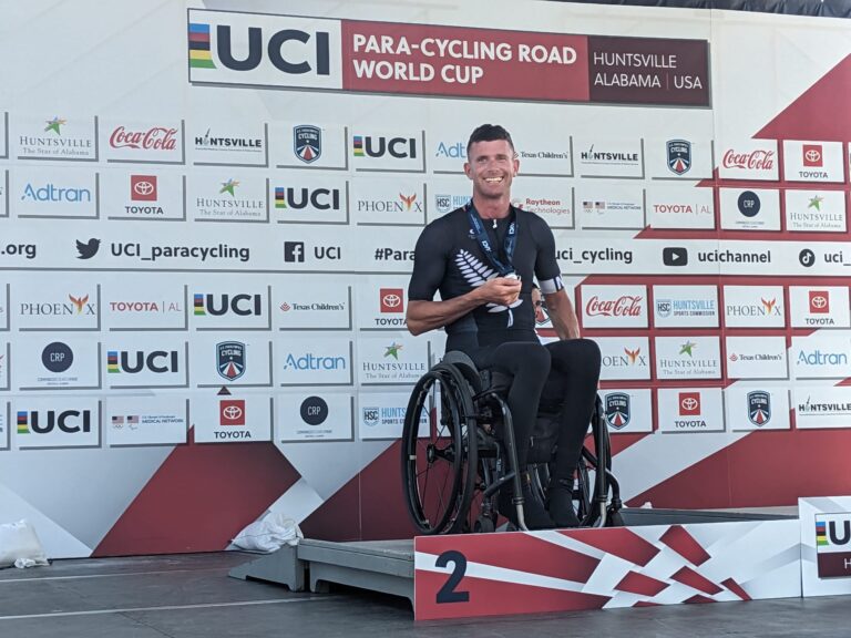 Rory Mead in wheelchair, smiling in silver position on the podium