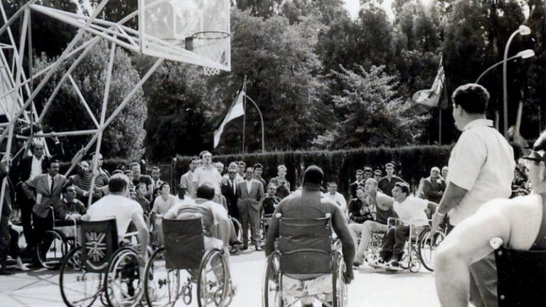 Black and white photo from 1960 Paralympics in Rome, athletes playing wheelchair basketball