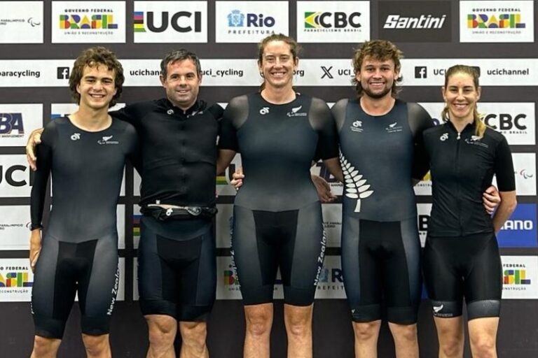 5 cyclists in skinsuits stand in front of a UCI media wall entitled "2024 Para Cycling Track World Championships"