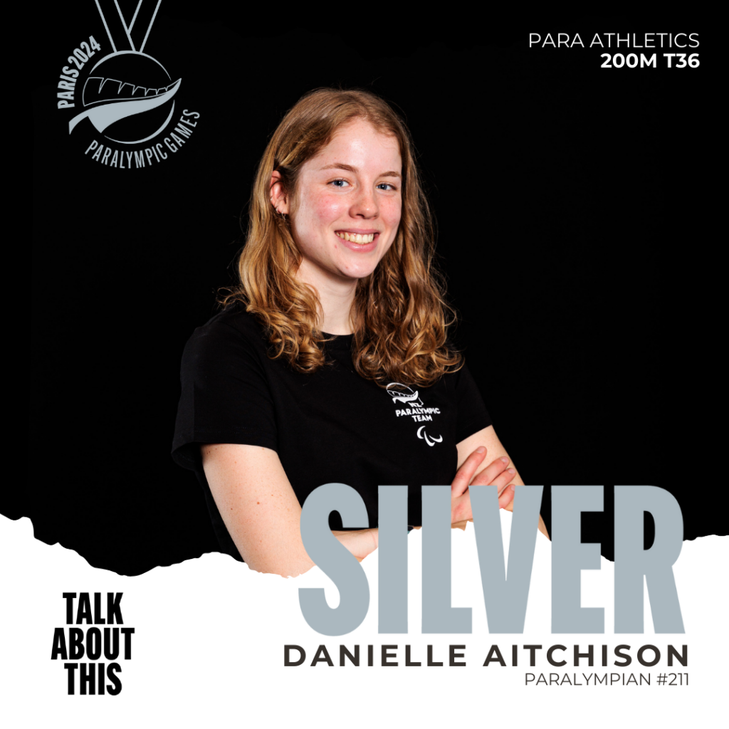 Danielle Aitchison standing in front of a black background with the word silver in front of her.