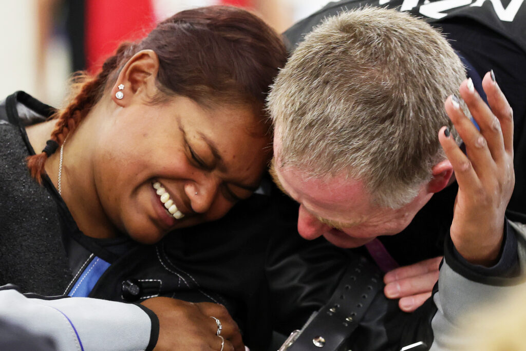 Neelam O'Neill and Greg Reid embrace in a hug following a challenging competition in the R3 Mixed 10m Air Rifle Prone SH1 qualification at the Paris 2024 Paralympic Games. 