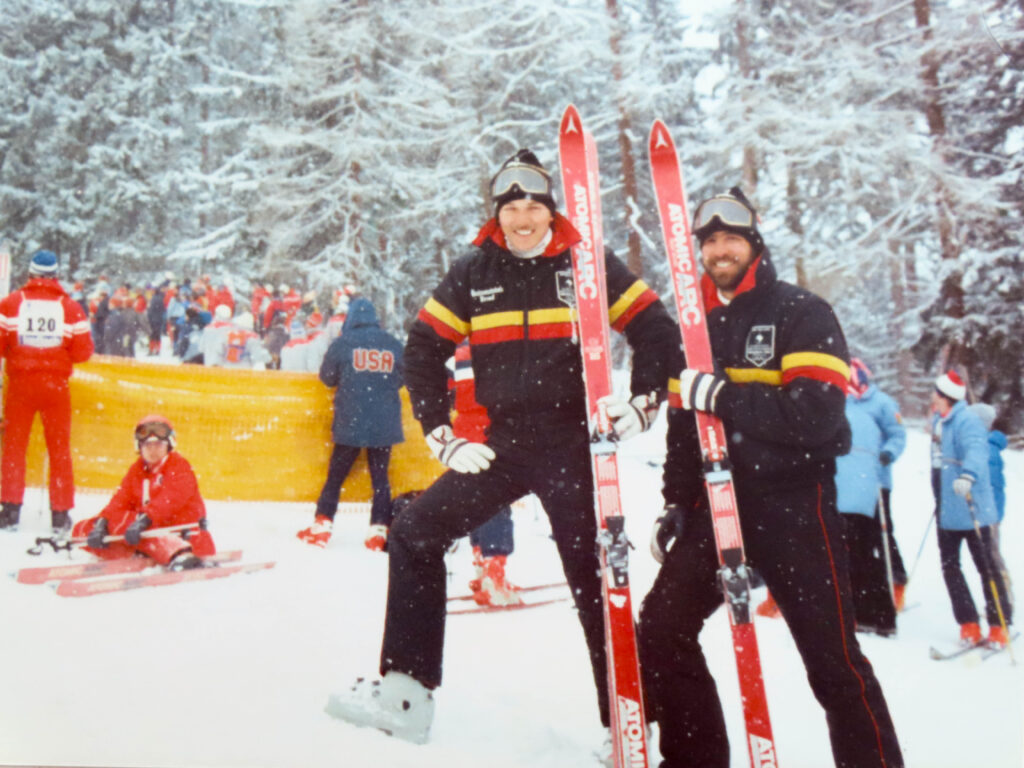 Sighted guide Roger McGarry (left) holds skis with blind skier Chris Orr at the 1984 Innsbruck Paralympic Games.