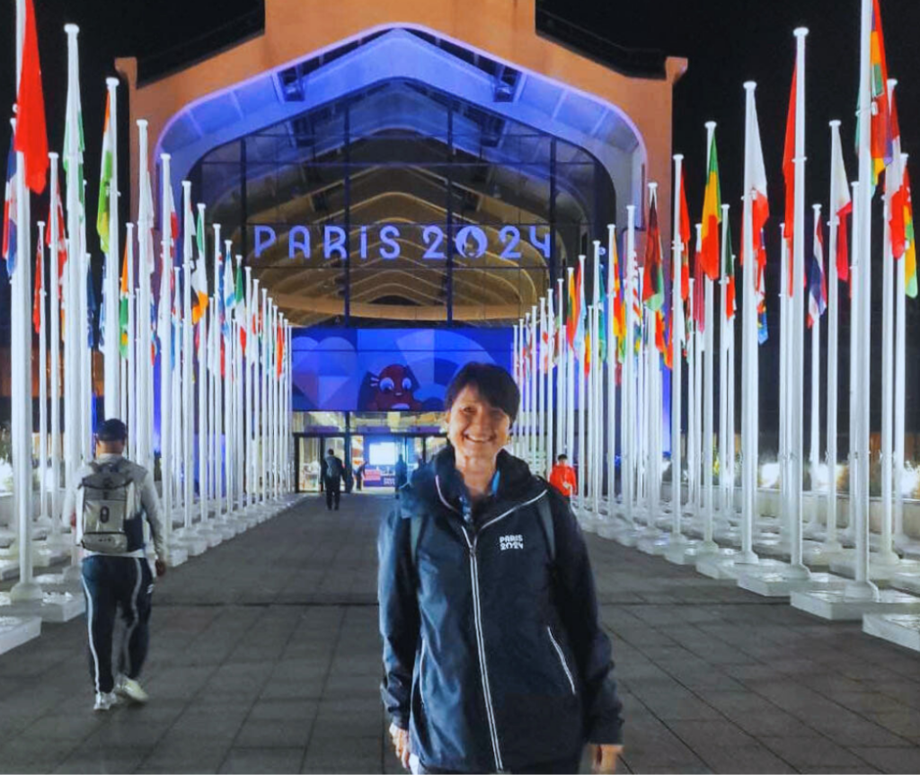 Kiwi Para canoe official Karen Simpson stands in front of the Paralympic Village at the Paris 2024 Paralympic Games.