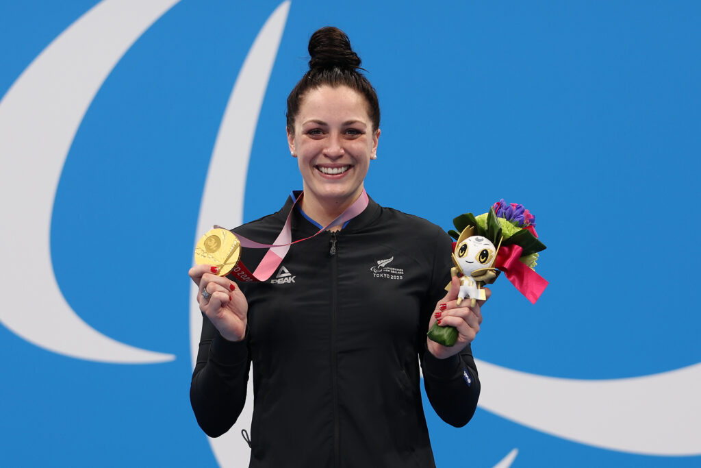 Paralympian #166 Dame Sophie Pascoe holds a gold medal from the Tokyo 2020 Paralympic Games.