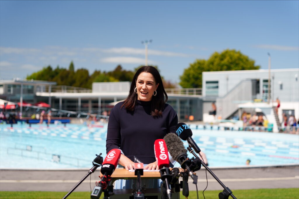 Dame Sophie Pascoe centre announces retirement in front of a number of microphones at Jellie Park, Christchurch.