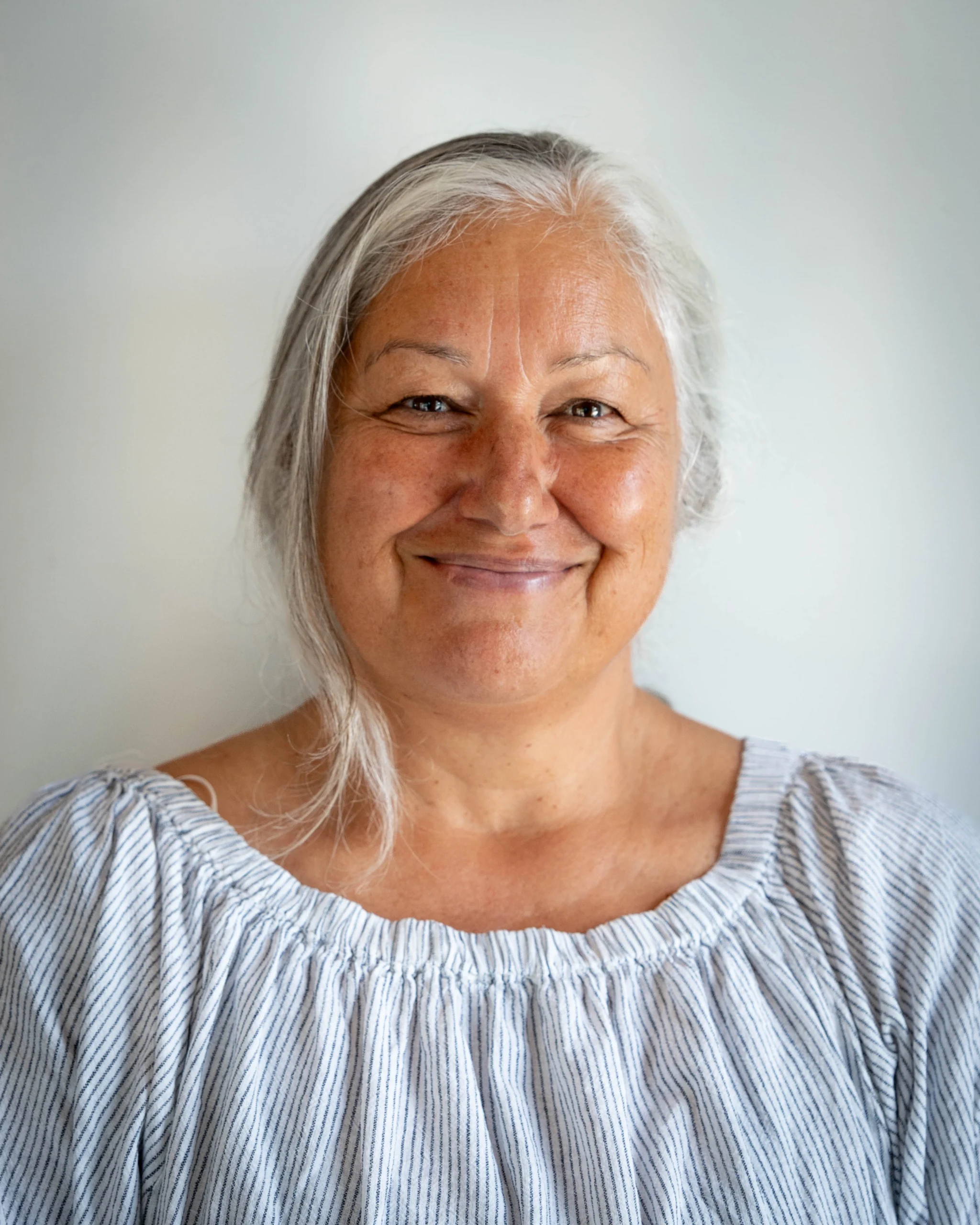 A professional portrait of Jana Rangooni on a white background.