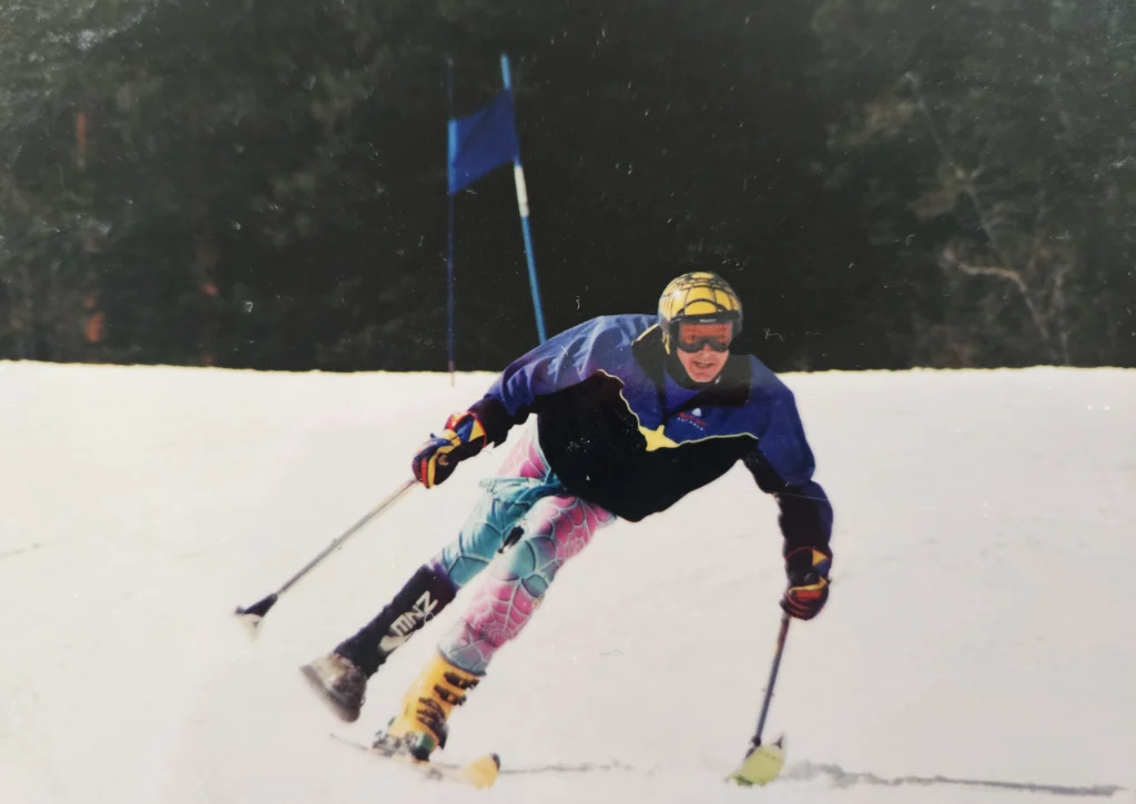 Kevin skis down a snowy mountain wearing vibrant colours.