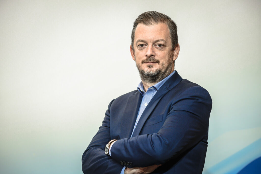 Portrait of Andrew Parsons dressed in a blue suit in front of a white background.
