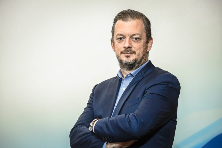 Portrait of Andrew Parsons dressed in a blue suit in front of a white background.