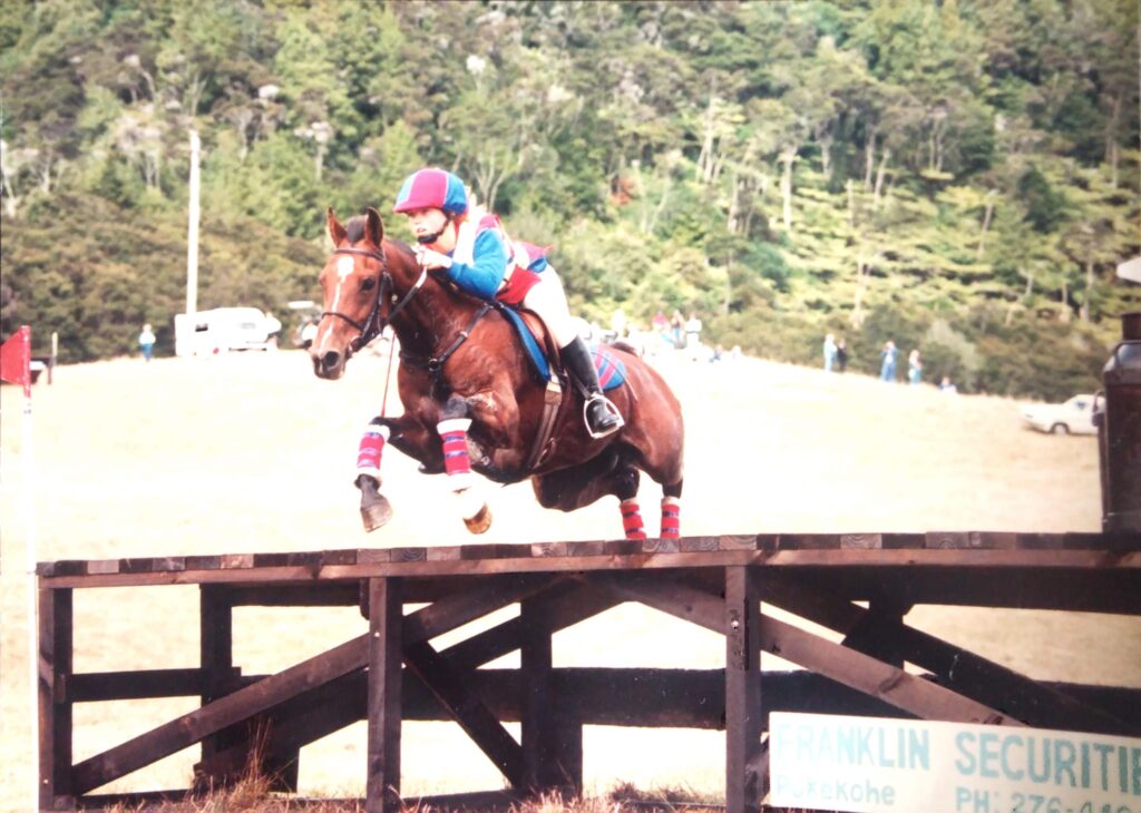 A young Nicola jumps a horse over a fence in competition.