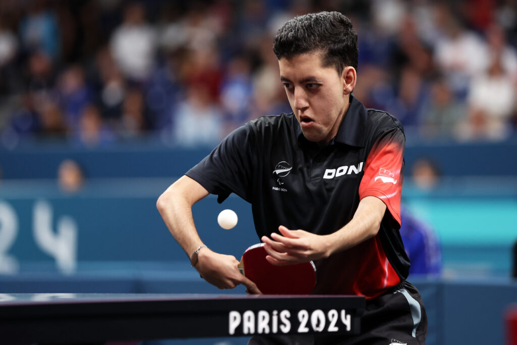 Matthew Britz swings his bat at a table tennis ball while competing at the Paris 2024 Paralympic Games.