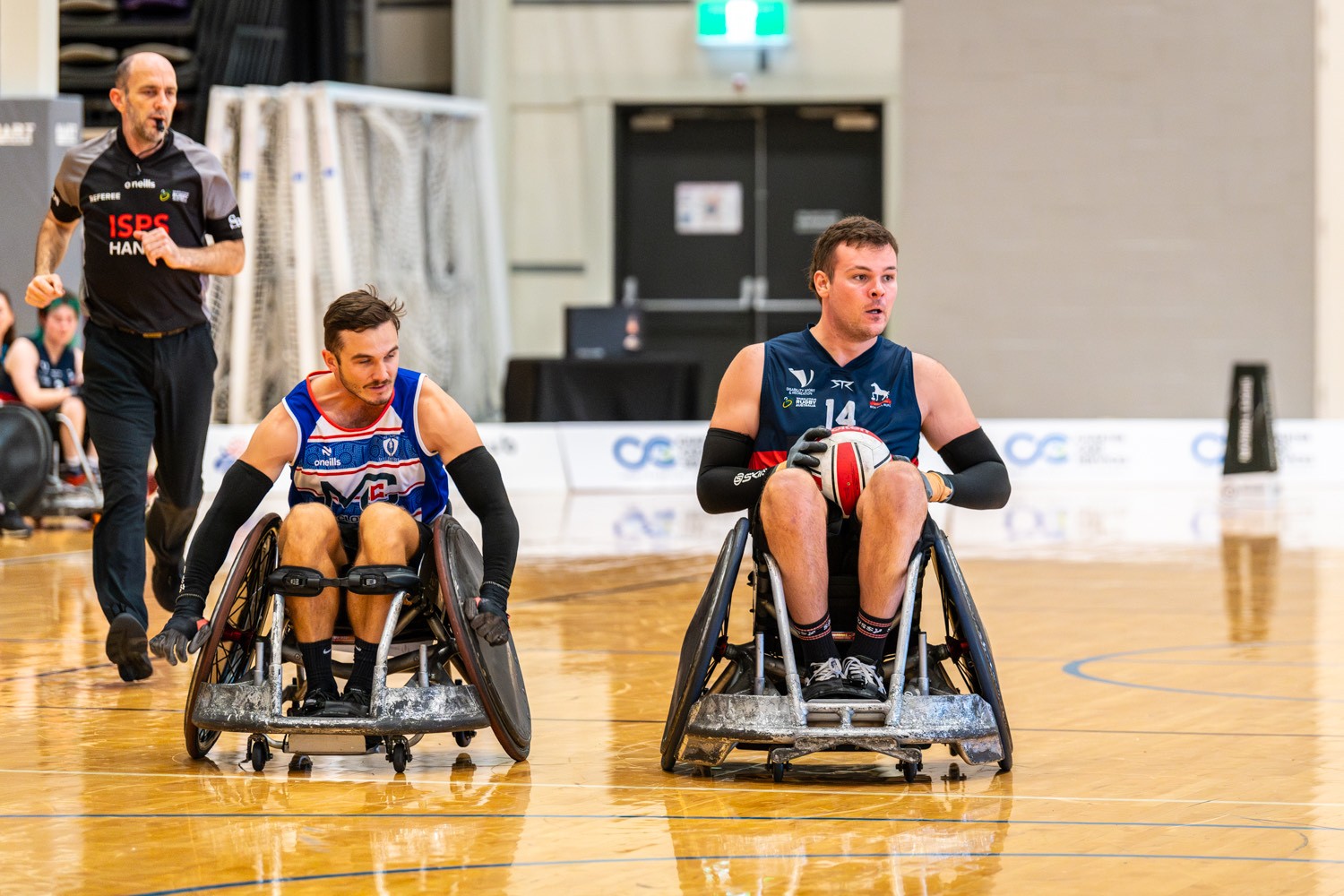 Keenan Alexander holds the ball in a game of Wheelchair rugby.