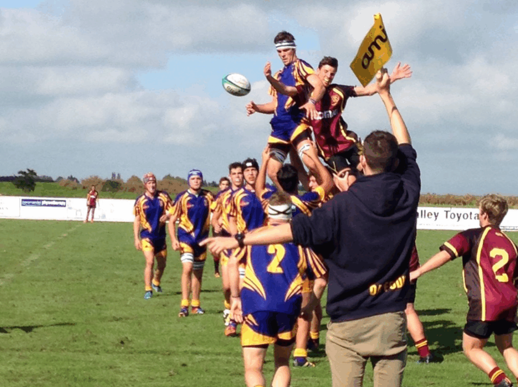 Keenan playing a game of rugby in a high school.
