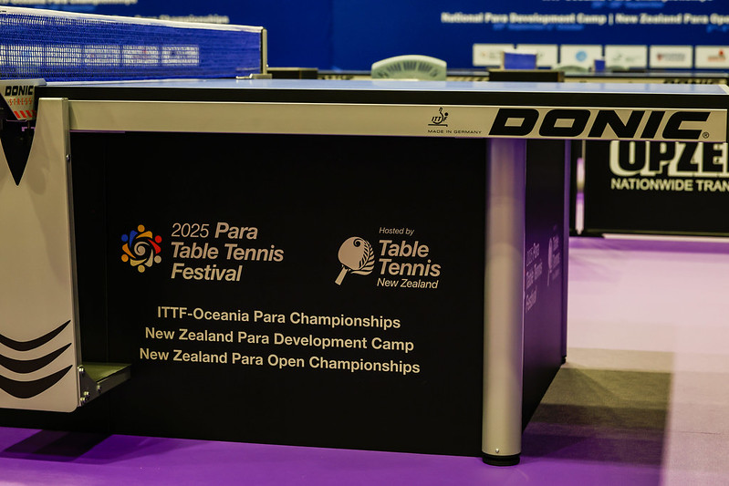 The logo for the Para Table Tennis Festival is seen on the lower wall of a Table Tennis table.