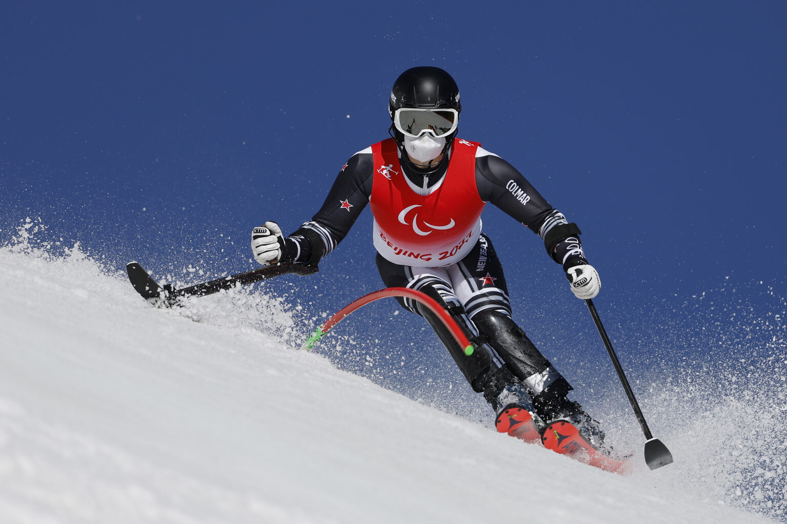 Adam Hall skies around a gate in a Para alpine skiing competition at Beijing 2022.