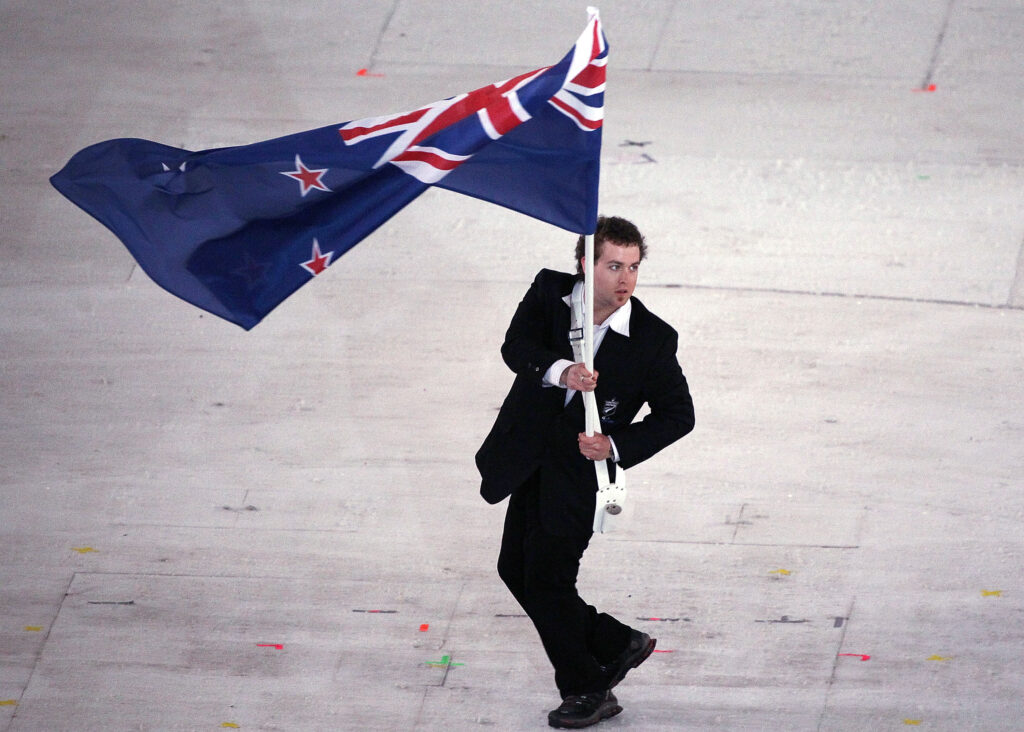 Adam hall waves the NZ flag at Vancouver 2010.