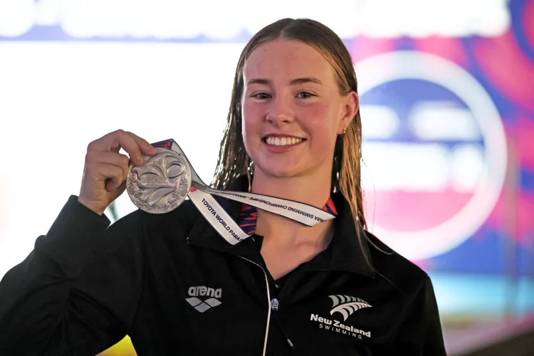 Gaby Smith raises her silver medal with a smile.