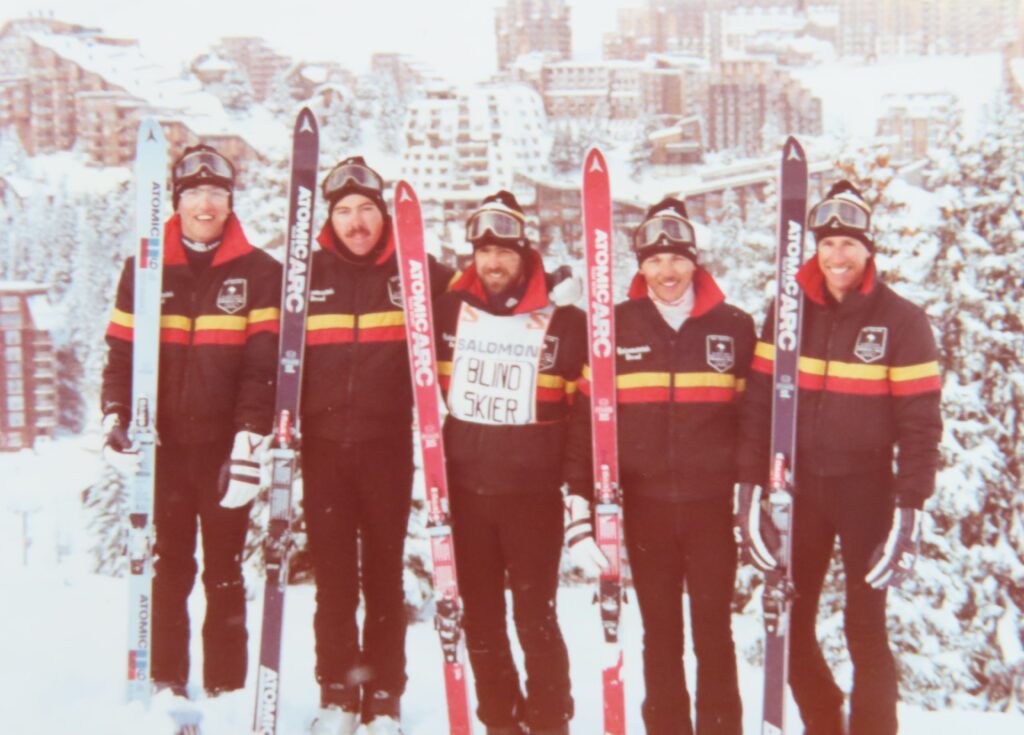 Chris Orr stands among peers of the NZ Paralympic Team on a snowy hill overlooking the town of Innsbruck.