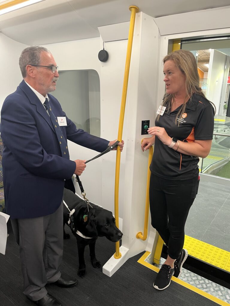 Chris Orr rides a train with his guide dog.